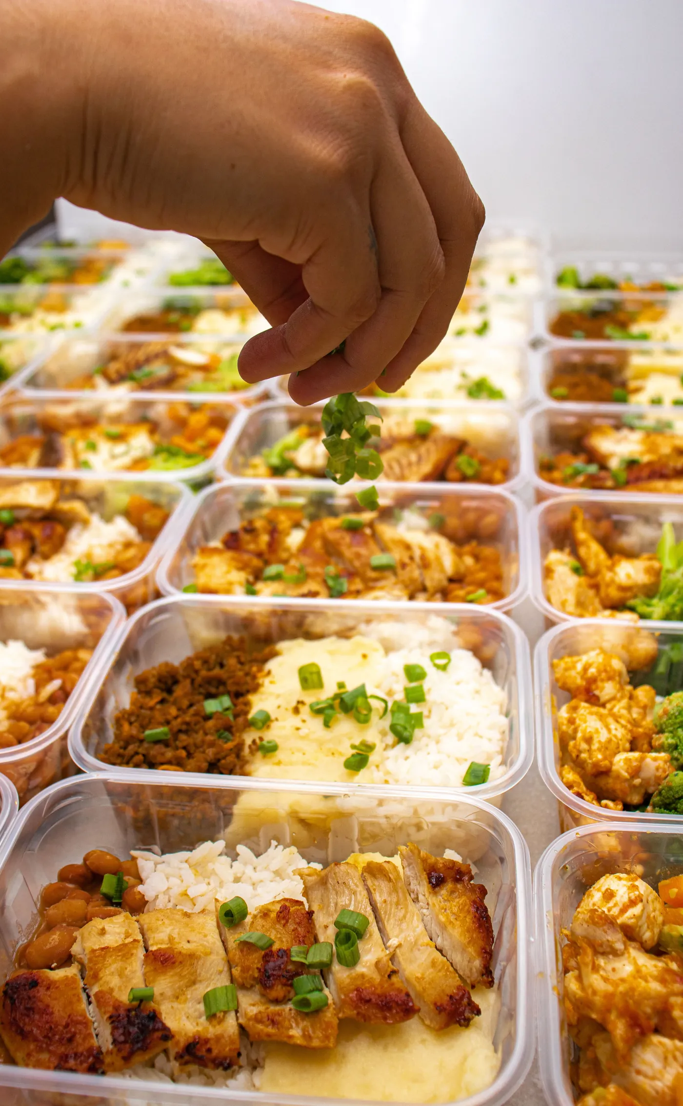 Finalização de refeições em embalagens individuais, organizadas para entrega. Fotografia ilustrativa da operação de delivery.